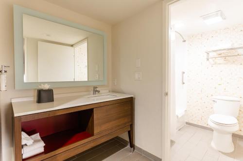 a bathroom with a sink and a toilet and a mirror at Holiday Inn Rancho Cordova - Northeast Sacramento, an IHG Hotel in Rancho Cordova