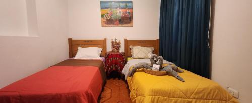 duas camas sentadas uma ao lado da outra num quarto em Lima Airport Hostel with FREE AIRPORT PICK UP em Lima