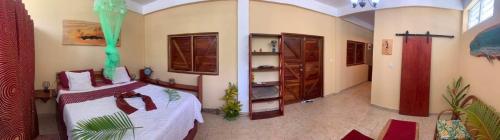 a bedroom with a bed and a cross on the wall at ORCHID RESORT Ltd in Guillet
