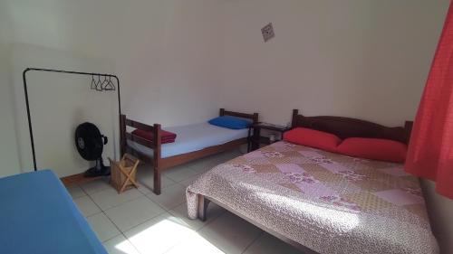 Dormitorio pequeño con cama y espejo en Hostel Meu Cantinho Caxambu Mg, en Caxambu