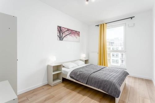 a white bedroom with a bed and a window at Chill Apartments Airport Ursynów in Warsaw