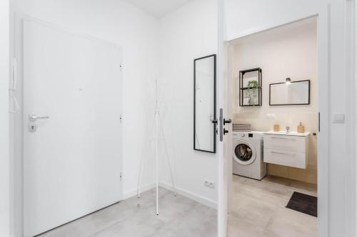 a white laundry room with a washer and dryer at Chill Apartments Airport Ursynów in Warsaw