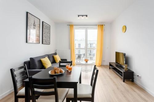a living room with a table and a couch at Chill Apartments Airport Ursynów in Warsaw