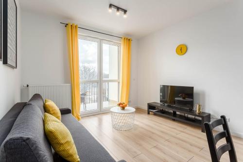 a living room with a couch and a tv at Chill Apartments Airport Ursynów in Warsaw