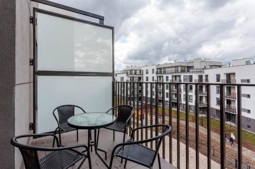 a balcony with chairs and a table and a window at Chill Apartments Airport Ursynów in Warsaw