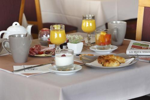 ブロワにあるIKAR - Fasthotel Bloisの食べ物の皿とオレンジジュースのグラスが置かれたテーブル