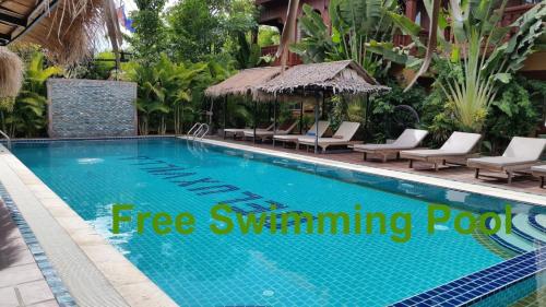 a swimming pool at a resort with text overlay free swimming pools at Lux Guesthouse in Battambang