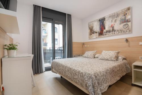 a bedroom with a bed and a large window at Hostal House in Barcelona