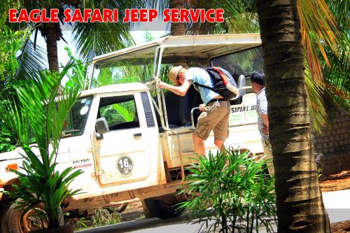 a man standing in the open door of a white van at The Coconut Gardens Hotel & Restaurant in Tissamaharama