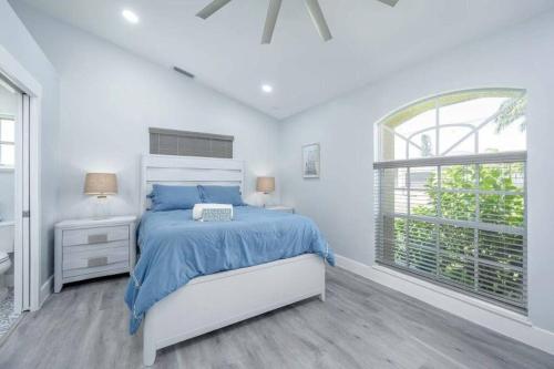 a white bedroom with a bed and a window at Once Upon A Tide - Cape Coral in Cape Coral