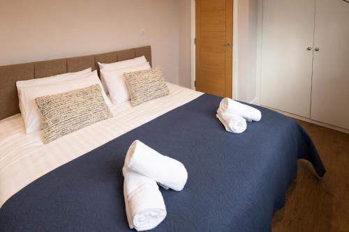 a bedroom with a large bed with towels on it at James Charles Apartments in Bletchley