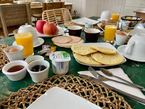 a table topped with plates of food and orange juice at Vent Des Dunes in Essaouira