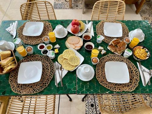 una mesa verde con platos de comida. en Vent Des Dunes, en Essaouira