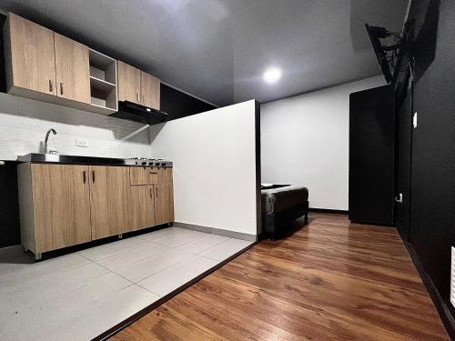a kitchen with wooden cabinets and a counter top at AW Hotel Ariston Airport in Bogotá