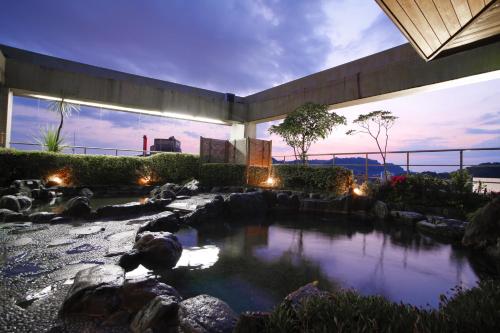 a garden with a pond in the middle of a building at Hanayuzuki in Matsuyama