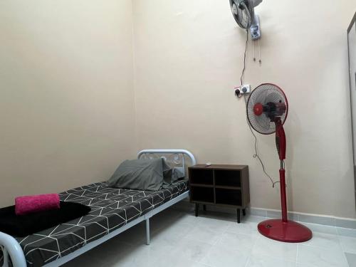 um quarto de hospital com uma cama e uma ventoinha em Homestay riha 2 em Kota Bharu