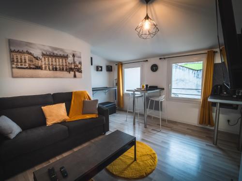 a living room with a couch and a table at Le P'tit Jeanne d'Arc in Nancy