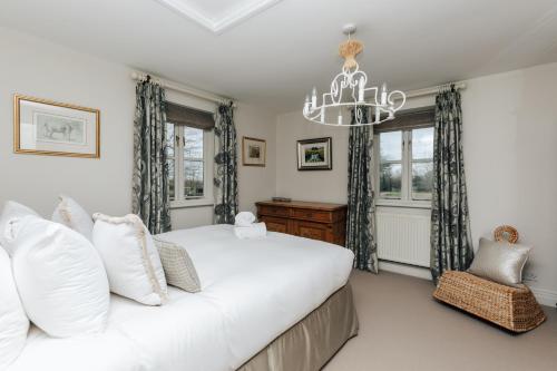 um quarto com uma cama grande e um lustre em The Whistler's Perch em Buckinghamshire