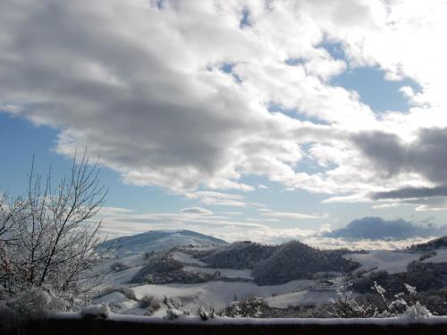 a view of a snow covered mountain range with clouds at Colleverde Country House & SPA Urbino in Urbino