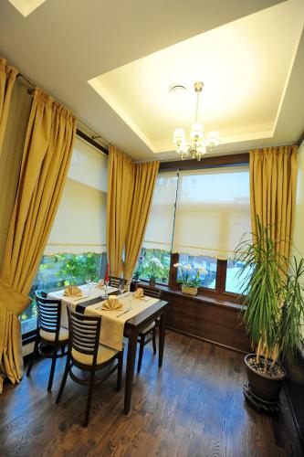 a dining room with a table and chairs and windows at ibis Styles Pitesti Arges in Piteşti