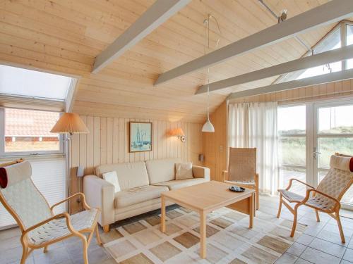 a living room with a couch and a table and chairs at Holiday Home Drusilla - 800m from the sea in Western Jutland by Interhome in Hvide Sande