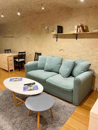 a living room with a blue couch and a table at Troglodyte du Petit Coteau in Vouvray
