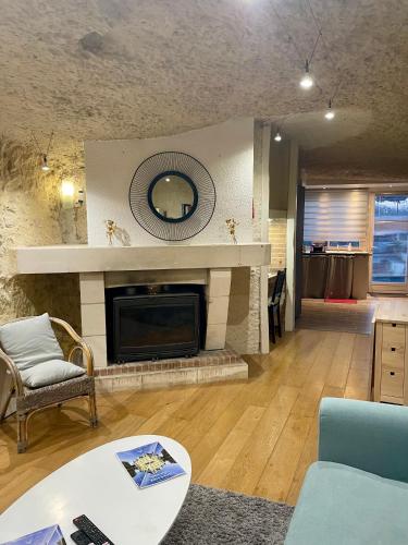 a living room with a fireplace and a couch at Troglodyte du Petit Coteau in Vouvray