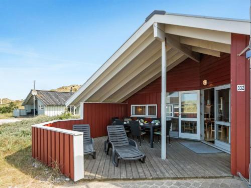 a deck with chairs and a table on a house at Holiday Home Tuure - from the sea in Western Jutland by Interhome in Bjerregård