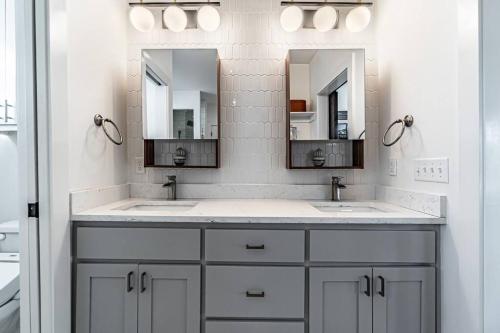 a bathroom with two sinks and two mirrors at The Rooftop Terrace on the Square in Bentonville