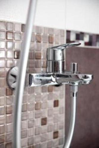 a bathroom sink with a faucet on a wall at Lam Bao Long Hotel in Hue