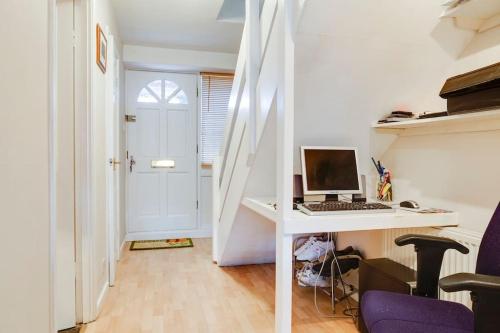 チェスターにあるCosy 3 Bed in the heart of Chesterのデスク(パソコン付)が備わる白い客室です。