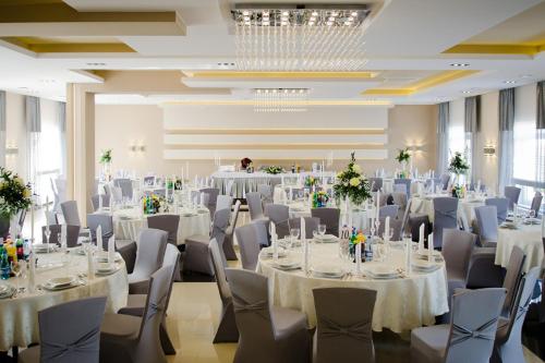 a banquet hall with white tables and chairs at Hotel Podkowa in Płock