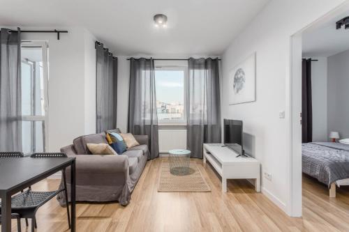 a living room with a couch and a bed at Chill Apartments Airport Ursynów in Warsaw