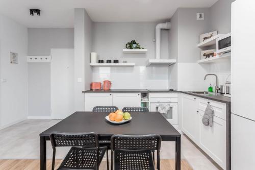 a kitchen with a table with a bowl of fruit on it at Chill Apartments Airport Ursynów in Warsaw