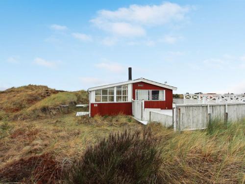 a red house sitting on top of a beach at Holiday Home Annelotte - from the sea by Interhome in Bjerregård