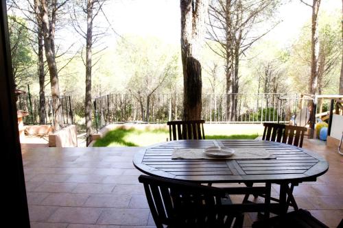 una mesa de madera con sillas en el patio en Casa Sara&Chiara, en Santa Margherita di Pula