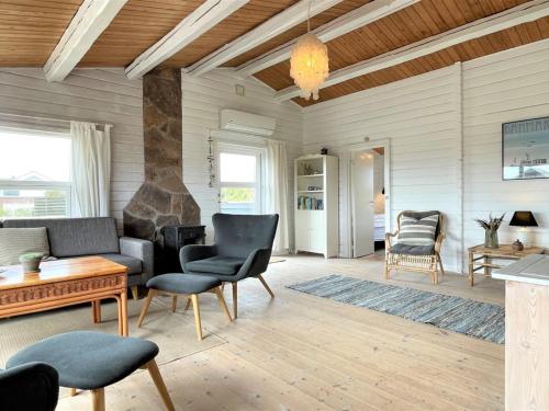ein Wohnzimmer mit einem Sofa, Stühlen und einem Tisch in der Unterkunft Holiday Home Arbnora - 400m from the sea in Western Jutland by Interhome in Bjerregård