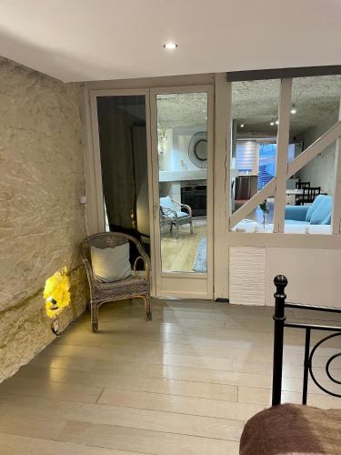 a living room with a chair and a bedroom at Troglodyte du Petit Coteau in Vouvray