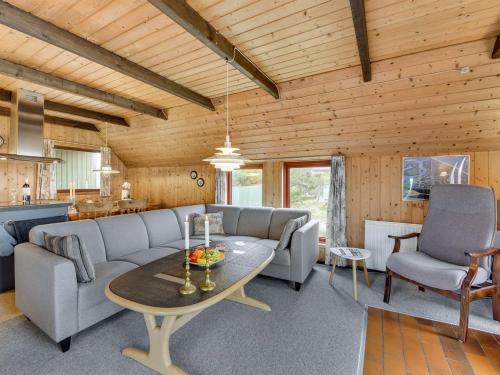 ein Wohnzimmer mit einem Sofa und einem Tisch in der Unterkunft Holiday Home Rayne - from the sea in Western Jutland by Interhome in Bjerregård