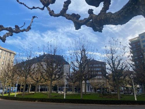 un grupo de árboles en un parque con edificios en Domus Santa Clara Céntrico apartamento con Wifi, en León