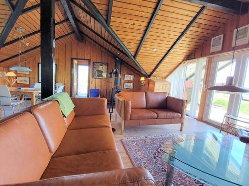 uma sala de estar com mobiliário de couro e uma mesa de vidro em Holiday Home Beneta - 300m from the sea in Western Jutland by Interhome em Hvide Sande