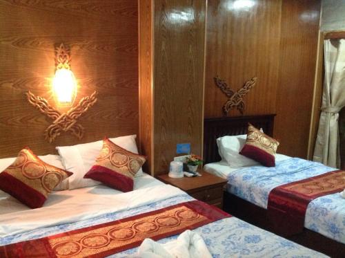 a hotel room with two beds and a lamp at Ruan Mai Naiyang Beach Resort in Nai Yang Beach