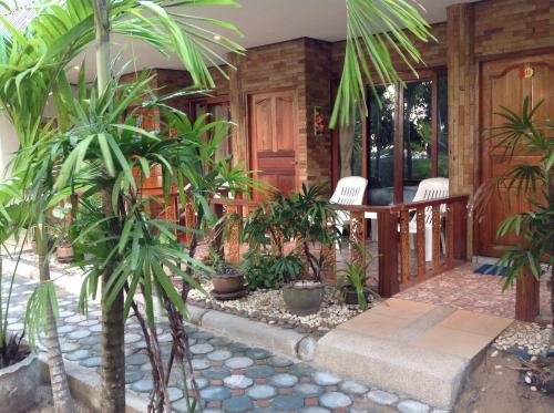 a porch of a house with a bunch of plants at Ruan Mai Naiyang Beach Resort in Nai Yang Beach