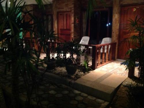 a porch of a house with chairs and plants at Ruan Mai Naiyang Beach Resort in Nai Yang Beach