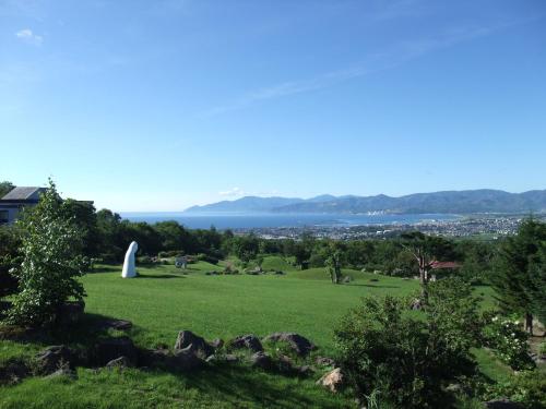 a view of a park with a sailboat in the distance at Iwanai Kogen Hotel in Iwanai