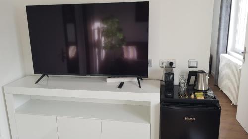 a flat screen tv sitting on a white entertainment center at Suite Deluxe, voyages d'affaires. in Saint-Nazaire