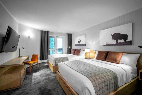 um quarto de hotel com duas camas e uma televisão em Lake Louise Inn em Lake Louise