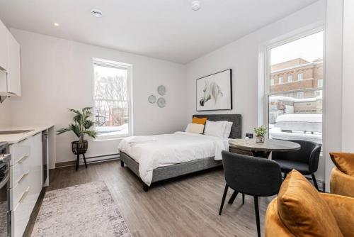 a bedroom with a bed and a table and chairs at Amazing New Apartment Close to Mount Royal Le Plateau by Denstays in Montréal