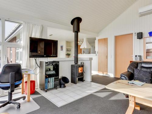a living room with a fireplace and a stove at Holiday Home Gottfreda - 330m to the inlet in Western Jutland by Interhome in Havrvig