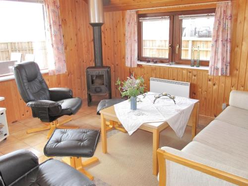 een woonkamer met een tafel en een fornuis bij Holiday Home Beatrice - 150m from the sea in Western Jutland by Interhome in Lemvig